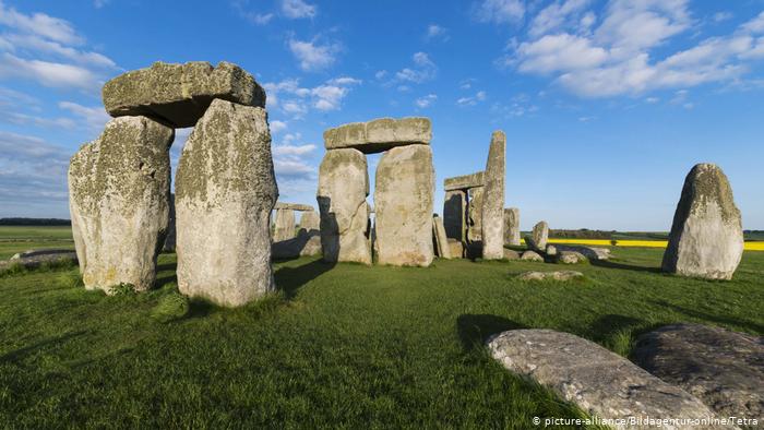 Stonehenge monuments on a green meadow.