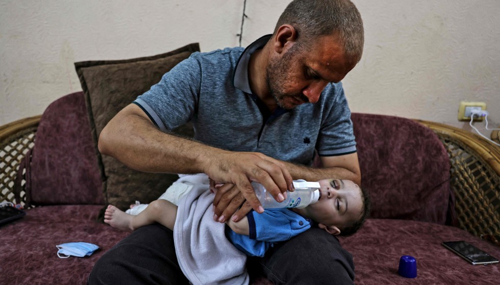 Many Lost: Palestinian Muhammad al-Hadidi in his brother's apartment in Gaza, where he gives his son milk from a bottle.  The child Omar was pulled alive from the rubble after their house was bombed.  His mother and four siblings have not been found.  Photo: AFP / NTB