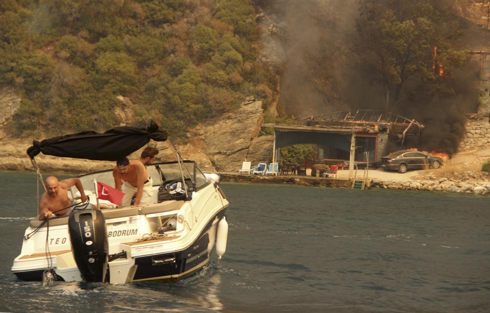 The summer paradise along the coast near Bodrum in Turkey turned into a blazing inferno as people desperately fled the flames in holiday boats on Sunday.  Photo: IHA via AP / NTB Photo: AP