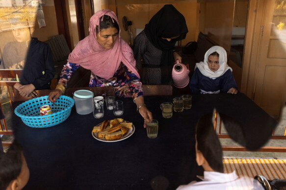 A staff member at the orphanage serves bread and tea for breakfast.