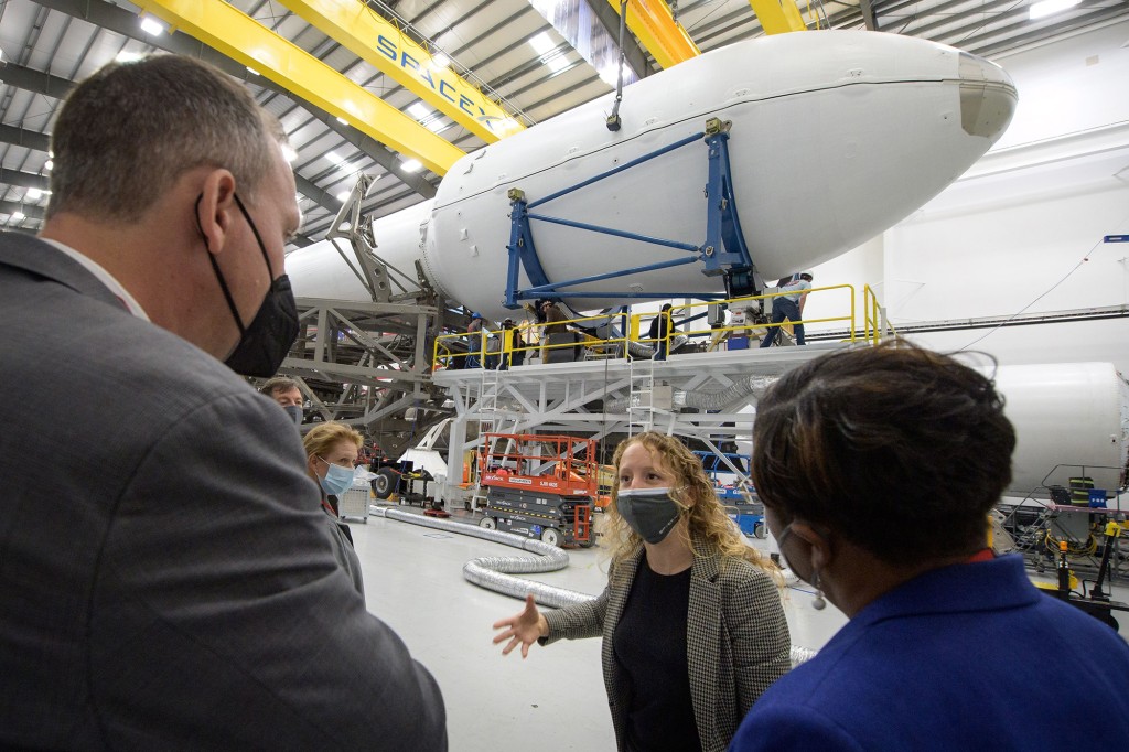 NASA Associate Administrator for Science Mission Directorate Thomas Zurbuchen, left, and other NASA leaders listen to Julianna Schiemann, SpaceX Director of Civilian Satellite Missions, center, visit the hangar where the Falcon 9 rocket and DART spacecraft are prepared for launch at Vandenberg Space Force Base in California. 