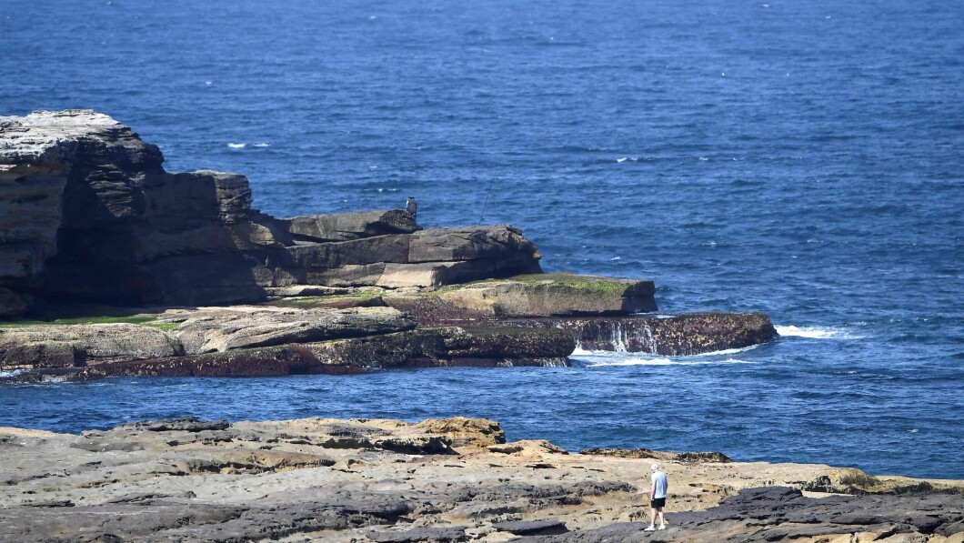 LITTLE BAY: A man walks along the cliffs in Little Bay Beach, where Briton Simon Nellist was attacked by sharks on Wednesday.  Authorities have deployed angelic stripes in an attempt to catch the giant white shark that has devoured Nelliste.  Photo: Mohamed Farouk/AFP/NTB