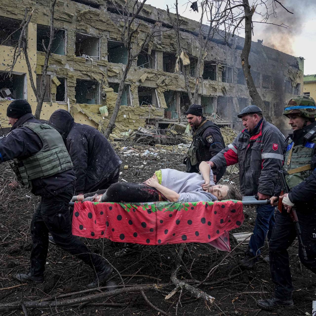 A pregnant woman is pulled out of the ruins of Maripol Hospital.