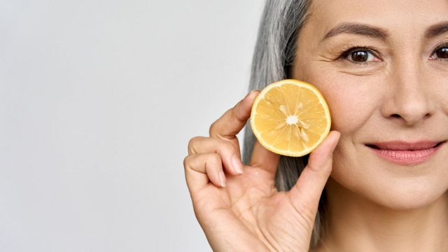 Mujer sosteniendo media naranja