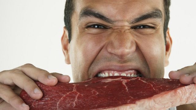 A man biting raw meat